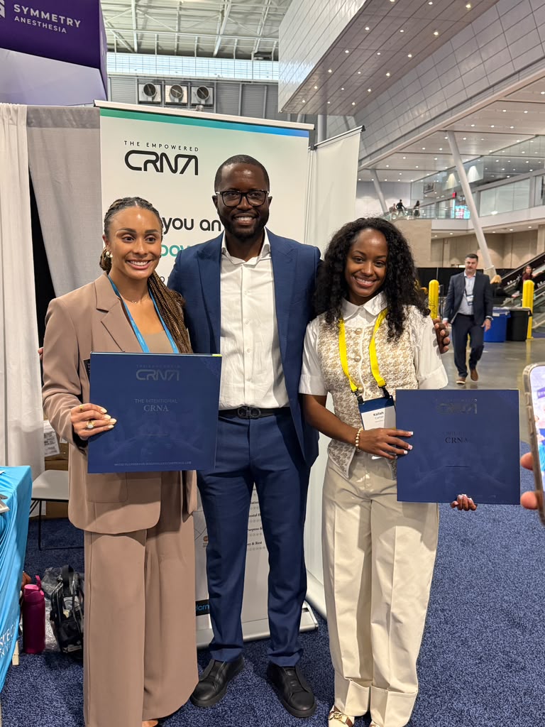 Leslie Awasom with two CRNAs at the Empowered CRNA booth at AANA 2026, each holding a copy of The Intentional CRNA
