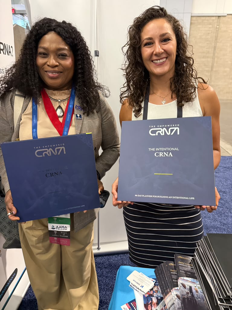 Two CRNAs at AANA 2026, each holding a copy of The Intentional CRNA